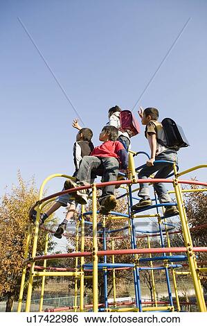 Stock Photograph - Four children playing on jungle gym. Fotosearch