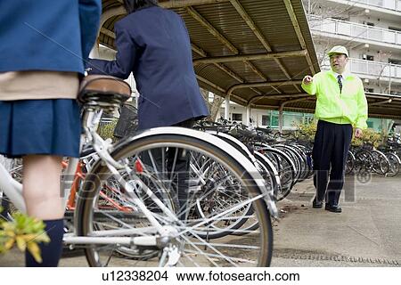 Picture - Super warning teenagers at bicycle parking lot. Fotosearch