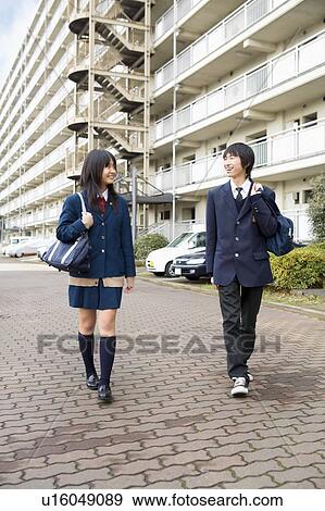 Teenage boy and girl walking in front of apartment building View Large Photo Image Stock Photo - Teenage boy and girl walking in front of apartment building. Fotosearch
