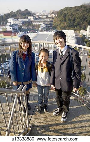 Stock Image - Teenagers and boy standing on stairs. Fotosearch