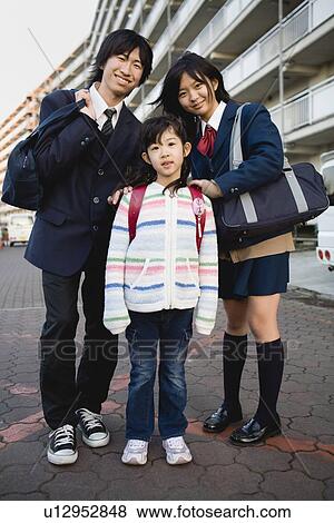 Teenagers and girl standing in front of housing complex View Large Photo Image Stock Photo - Teenagers and girl standing in front of housing complex. Fotosearch