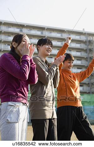 Stock Image - Three woman cheering. Fotosearch