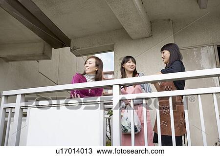 Stock Image - Three women chatting at hallway. Fotosearch