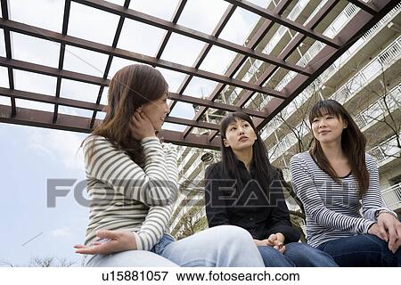 Stock Photo - Three women chatting at park. Fotosearch