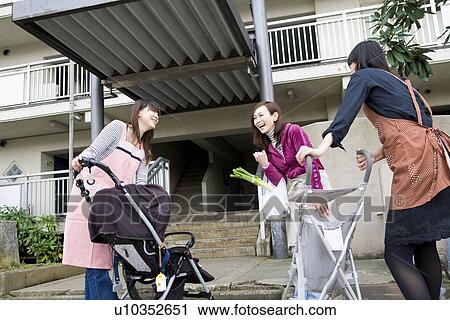 Three women chatting in front of apartment building View Large Photo Image Stock Image - Three women chatting in front of apartment building. Fotosearch