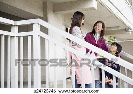 Stock Photography - Two women and boy chatting at steps. Fotosearch