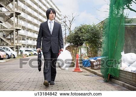 Young man walking with a garbage bag View Large Photo Image Stock Image - Young man walking with a garbage bag. Fotosearch