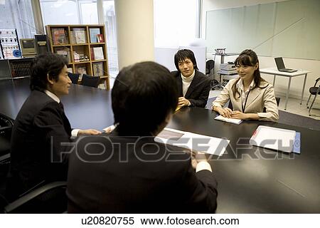 Four people meeting at table View Large Photo Image Stock Photography - Four people meeting at table. Fotosearch