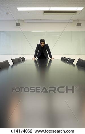 Stock Image - Portrait of mature man at meeting table. Fotosearch