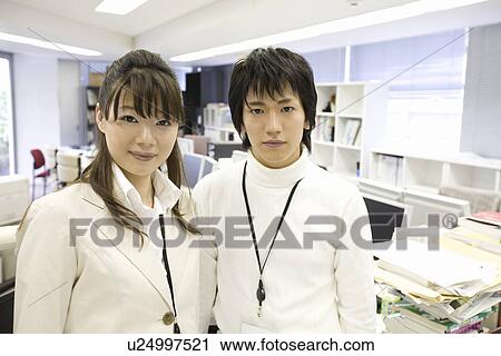 Stock Image - Portrait of young man and woman in office. Fotosearch