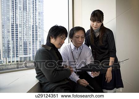 Three people checking file by the window View Large Photo Image Stock Image - Three people checking file by the window. Fotosearch