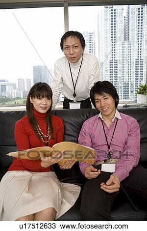 Stock Image - Three people meeting at sofa. Fotosearch