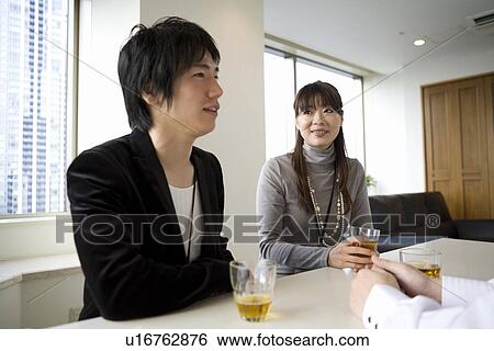 Three people meeting at table View Large Photo Image Stock Photograph - Three people meeting at table. Fotosearch
