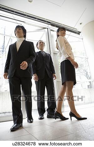Three people standing at entrance View Large Photo Image Stock Photo - Three people standing at entrance. Fotosearch