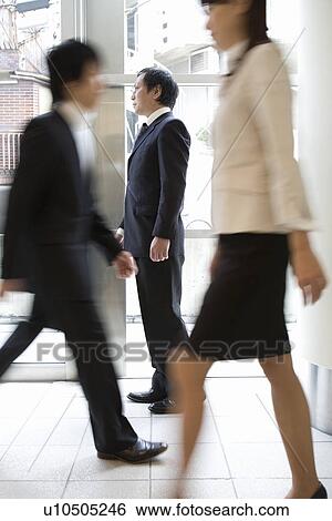 Three people walking in office View Large Photo Image Stock Photograph - Three people walking in office. Fotosearch