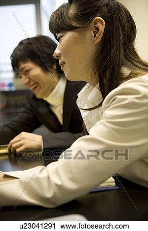 Stock Image - Two people meeting at table. Fotosearch