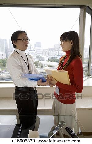 Stock Image - Two person meeting by the window. Fotosearch