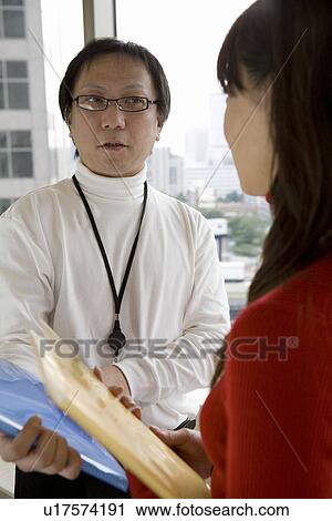 Stock Image - Two person meeting by the window. Fotosearch