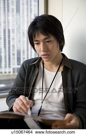 Young man checking documents View Large Photo Image Picture - Young man checking documents. Fotosearch