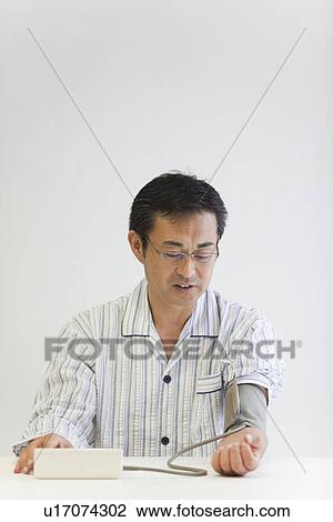 Mature man checking blood pressure View Large Photo Image Stock Image - Mature man checking blood pressure. Fotosearch