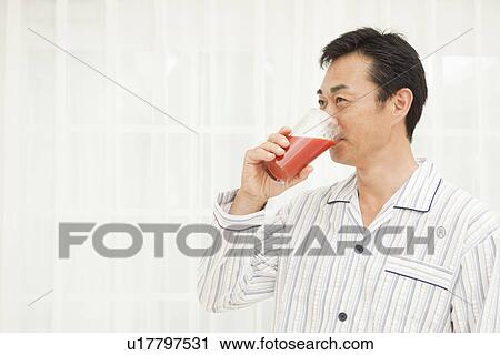 Stock Image - Mature man drinking vegetable juice. Fotosearch