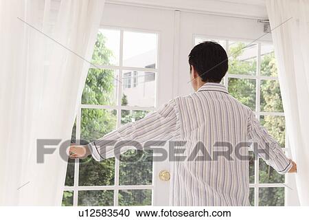Mature man in pajama standing in front of window View Large Photo Image Stock Image - Mature man in pajama standing in front of window. Fotosearch
