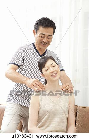 Stock Image - Mature man massaging mature woman's shoulder. Fotosearch