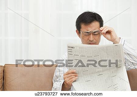 Stock Photo - Mature man reading newspaper. Fotosearch