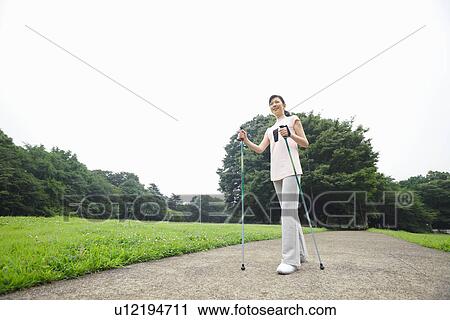 Mature woman enjoying Nordic walking View Large Photo Image Stock Image - Mature woman enjoying Nordic walking. Fotosearch
