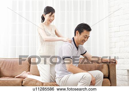 Stock Photograph - Mature woman massaging mature man's shoulder. Fotosearch