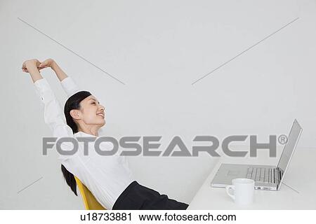 Mid adult businesswoman stretching View Large Photo Image Stock Image - Mid adult businesswoman stretching. Fotosearch