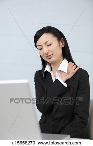 Mid adult businesswoman suffering from pain on shoulder View Large Photo Image Stock Image - Mid adult businesswoman suffering from pain on shoulder. Fotosearch