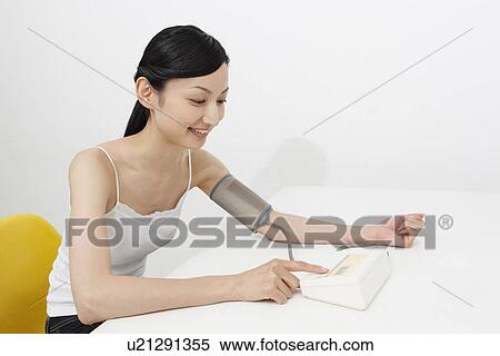 Mid adult woman checking blood pressure View Large Photo Image Stock Photography - Mid adult woman checking blood pressure. Fotosearch