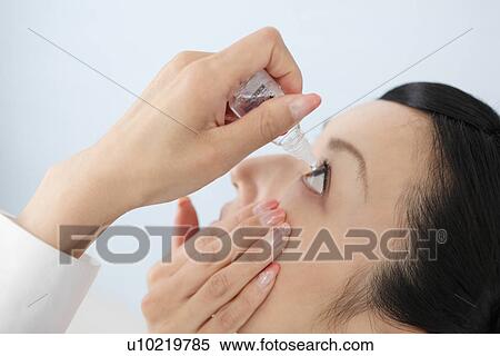 Mid adult woman putting eye-drops View Large Photo Image Stock Photography - Mid adult woman putting eye-drops. Fotosearch