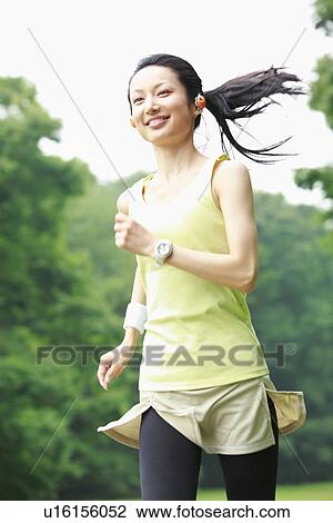 Stock Image - Mid adult woman running. Fotosearch
