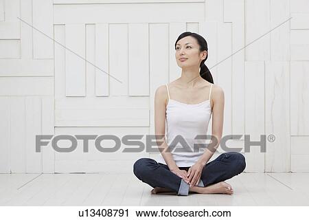 Stock Image - Mid adult woman sitting. Fotosearch