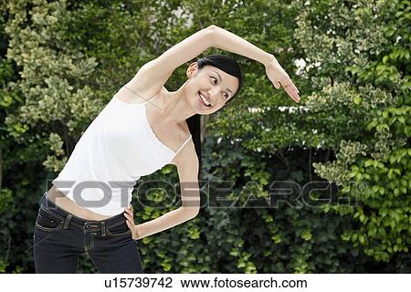 Mid adult woman stretching View Large Photo Image Stock Image - Mid adult woman stretching. Fotosearch