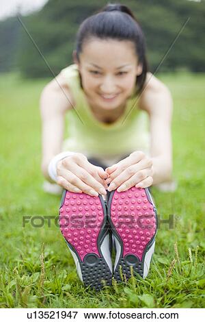 Mid adult woman stretching View Large Photo Image Stock Photo - Mid adult woman stretching. Fotosearch