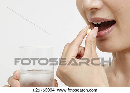 Mid adult woman taking supplement View Large Photo Image Picture - Mid adult woman taking supplement. Fotosearch