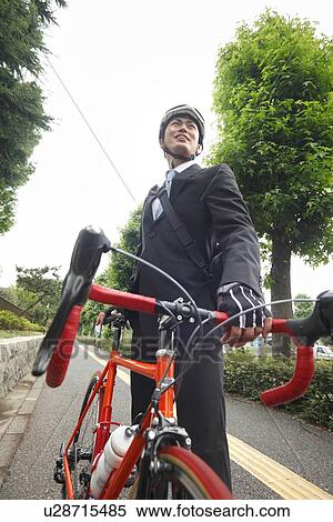 Young businessman holding bicycle View Large Photo Image Stock Photography - Young businessman holding bicycle. Fotosearch