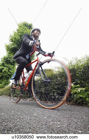 Young businessman riding bicycle View Large Photo Image Stock Image - Young businessman riding bicycle. Fotosearch
