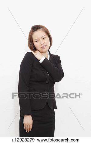 Young businesswoman suffering from pain on shoulder View Large Photo Image Stock Photo - Young businesswoman suffering from pain on shoulder. Fotosearch