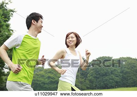 Stock Photo - Young man and woman running. Fotosearch