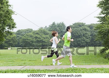 Stock Photo - Young man and woman running. Fotosearch