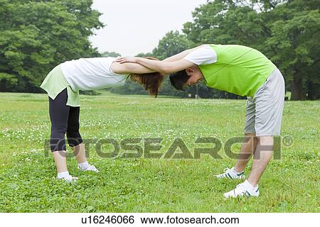 Young man and woman stretching View Large Photo Image Stock Photograph - Young man and woman stretching. Fotosearch