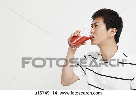 Picture - Young man drinking vegetable juice. Fotosearch