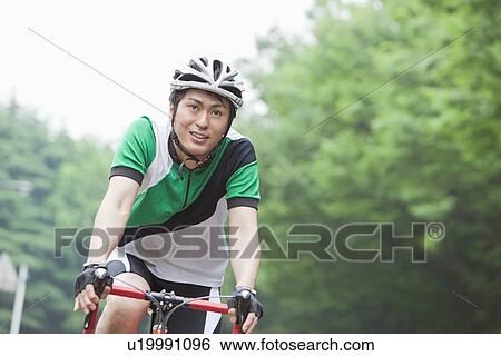 Stock Photograph - Young man riding bicycle. Fotosearch