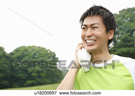 Stock Photo - Young man wiping sweat on face. Fotosearch