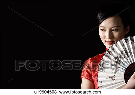 Close-up of young woman in Cheongsam with fan by face posing View Large Photo Image Stock Photo - Close-up of young woman in Cheongsam with fan by face posing. Fotosearch