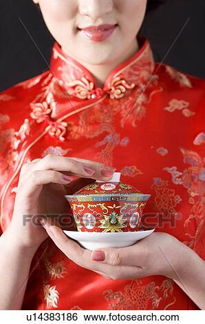 Close-up of young woman in Cheongsam holding cup of tea View Large Photo Image Stock Photograph - Close-up of young woman in Cheongsam holding cup of tea. Fotosearch